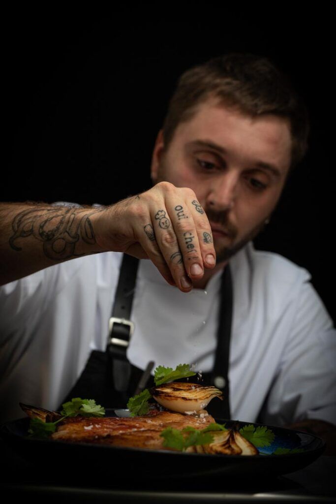 Cocinero preparando un plato en Tuétano restaurante en Mérida
